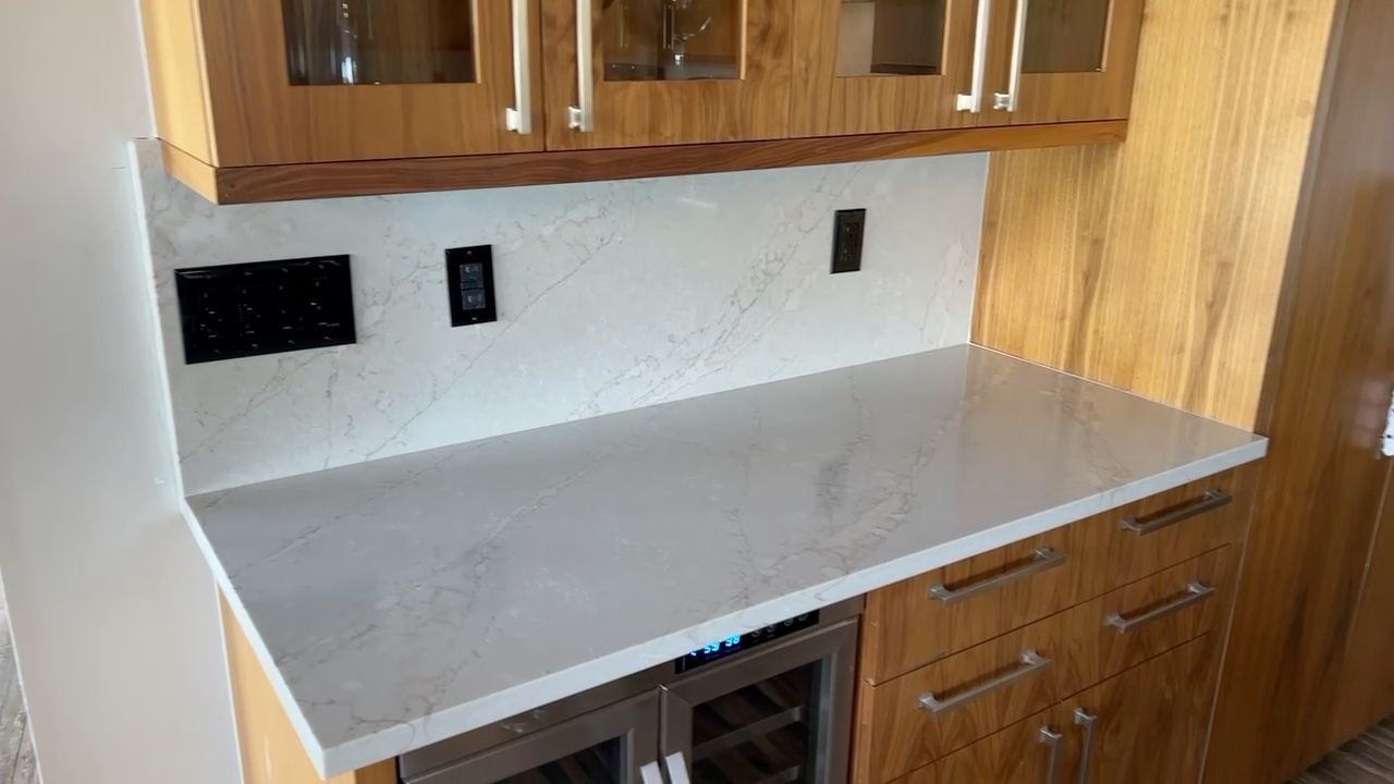 White countertop in a kitchen with wood cabinets and backsplash outlets