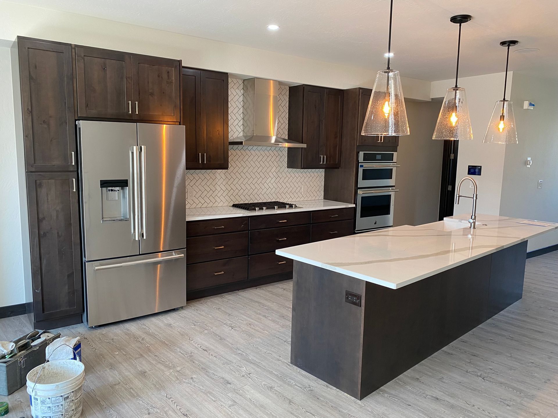 Modern kitchen with stainless steel appliances, dark cabinets, and a white island countertop