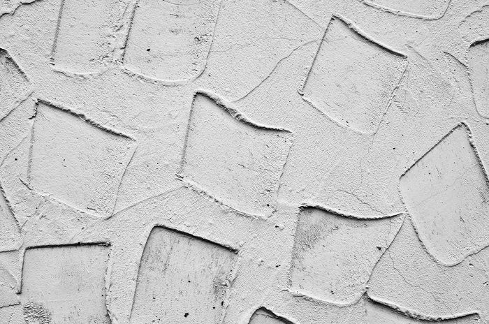 a black and white photo of a concrete wall with a geometric pattern .