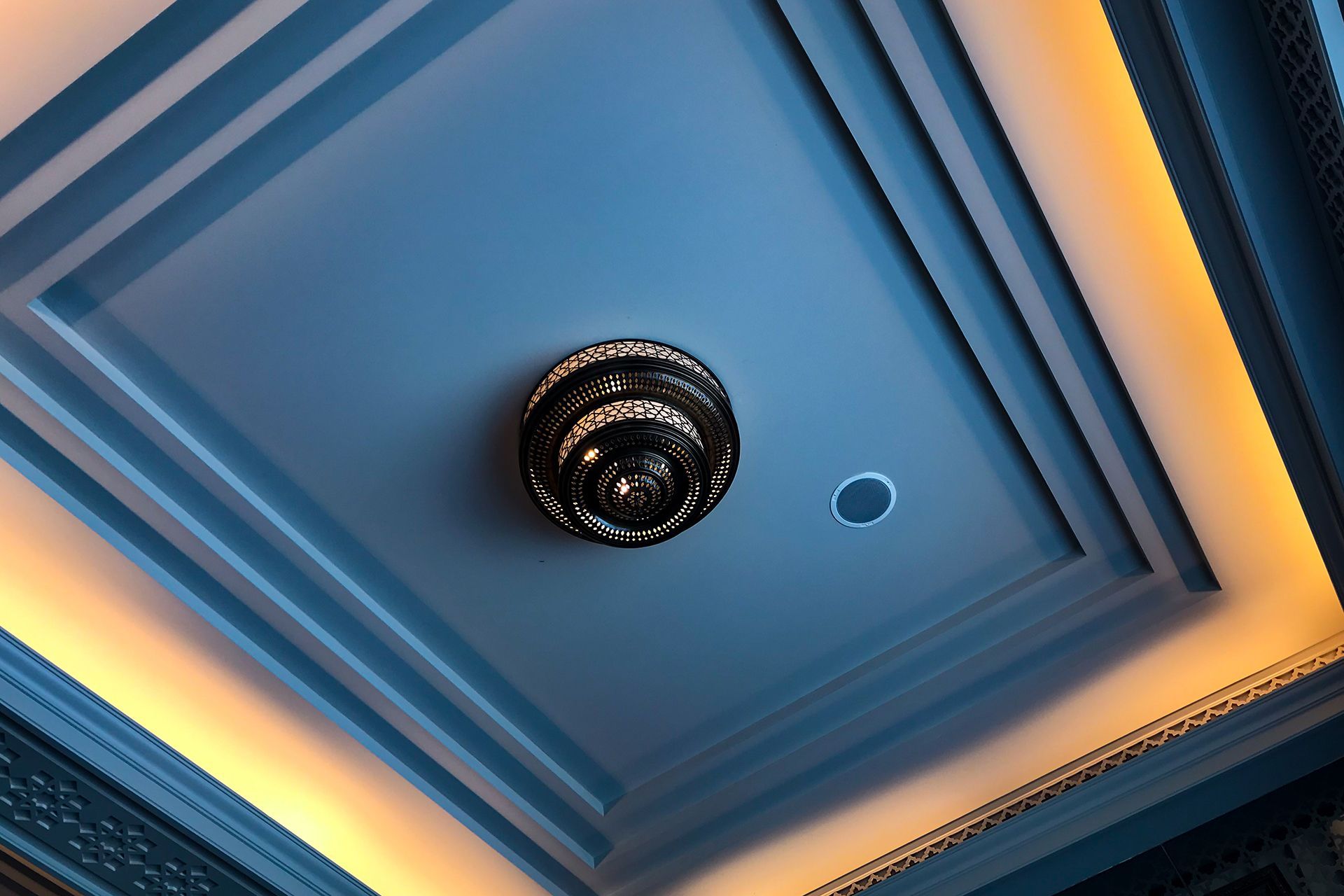 a blue ceiling with a chandelier hanging from it
