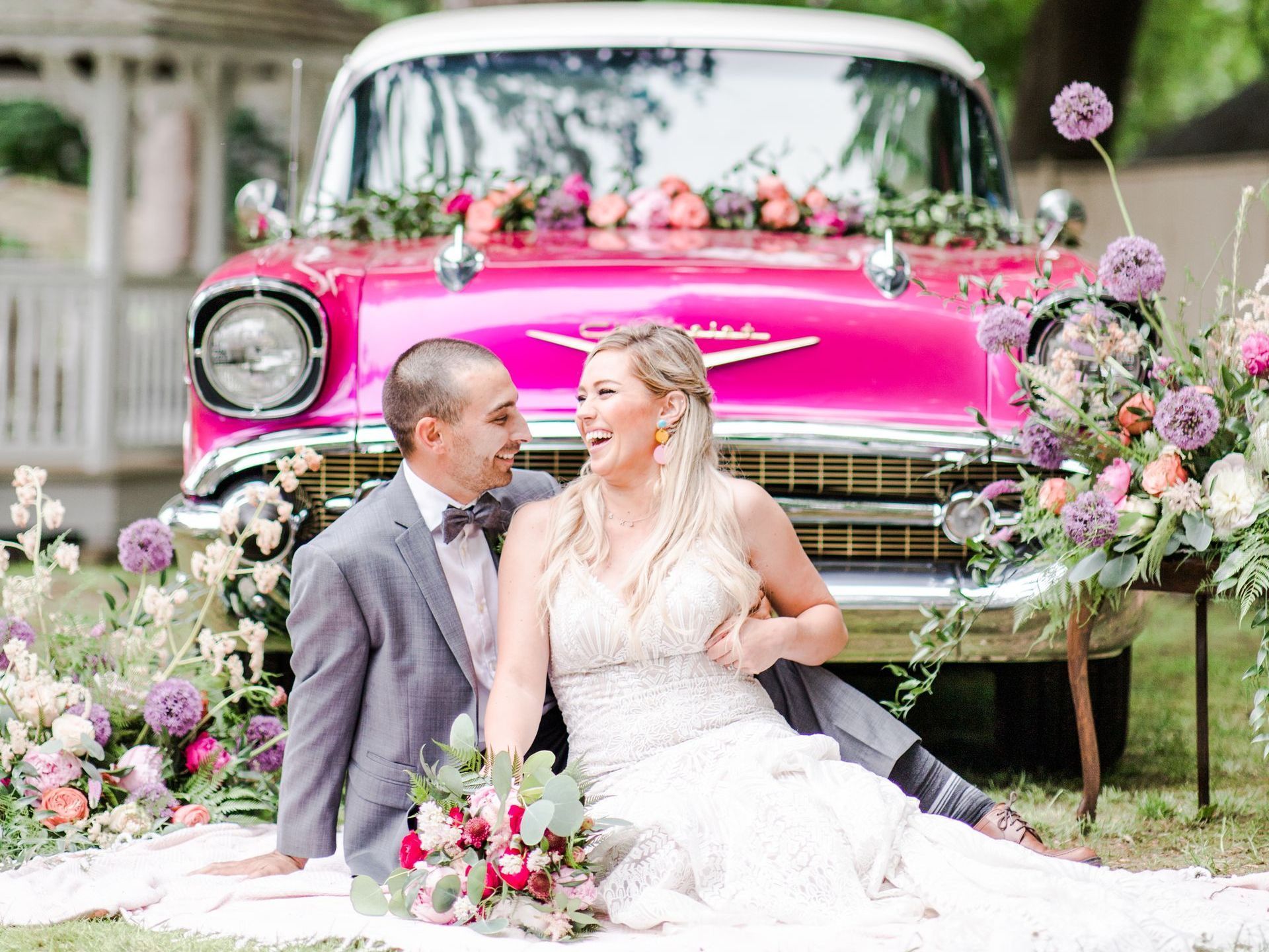 Bride and Groom sitting in front of car
