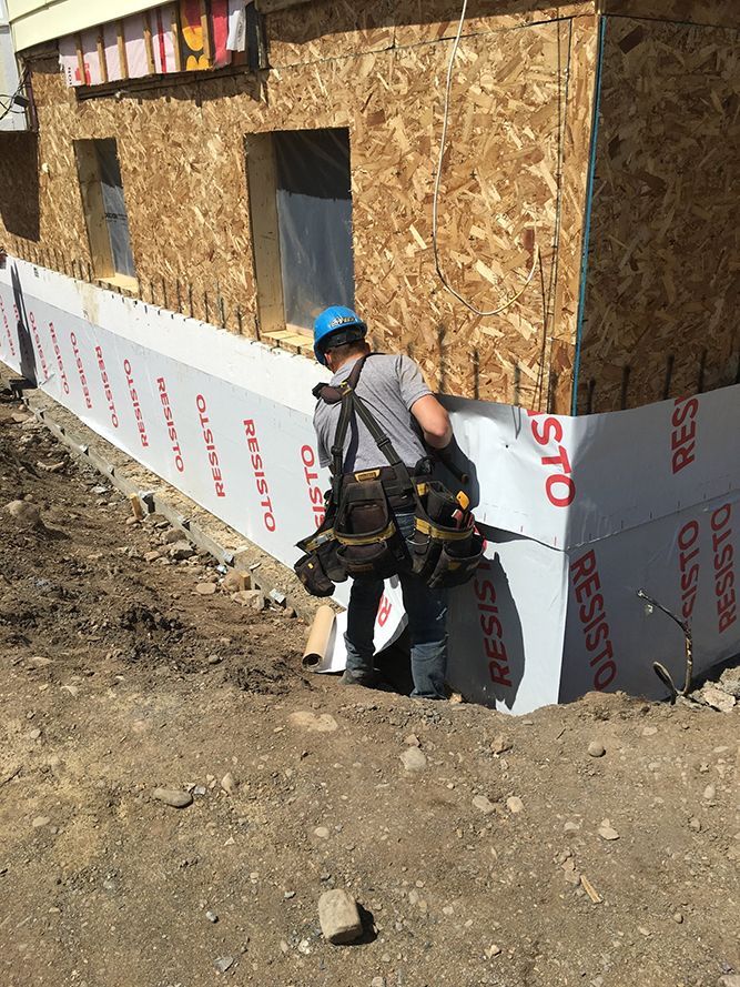 Un homme se tient devant un bâtiment en construction.