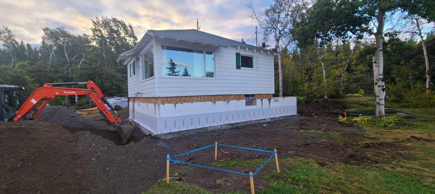 Une maison est en construction au sommet d'une colline de terre.