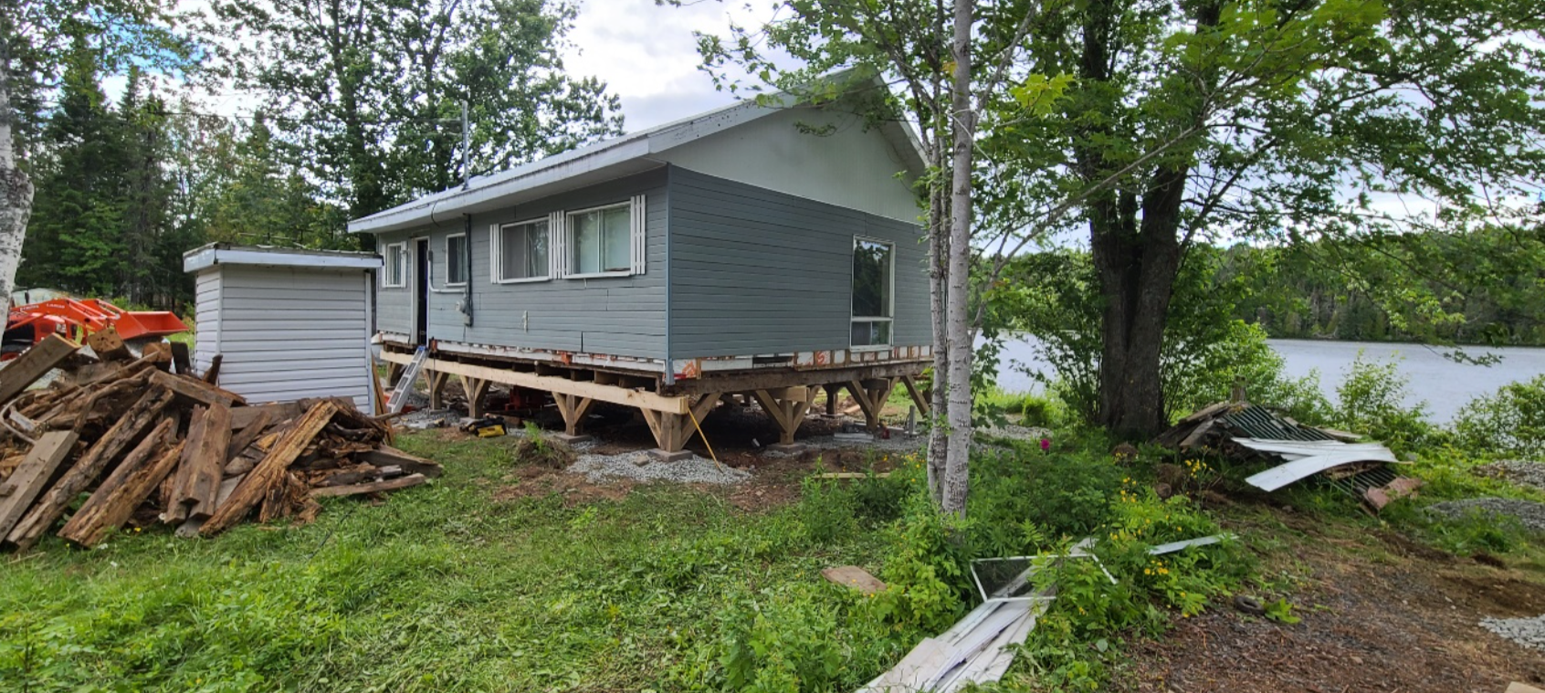 Une petite maison est déplacée vers un nouvel emplacement à côté d'un lac.