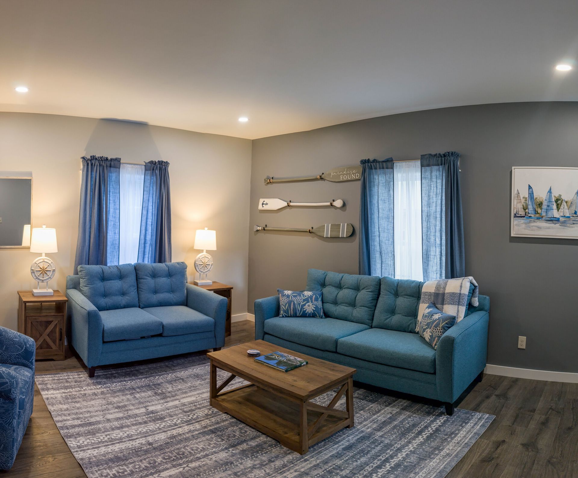 A living room with two blue couches and a coffee table