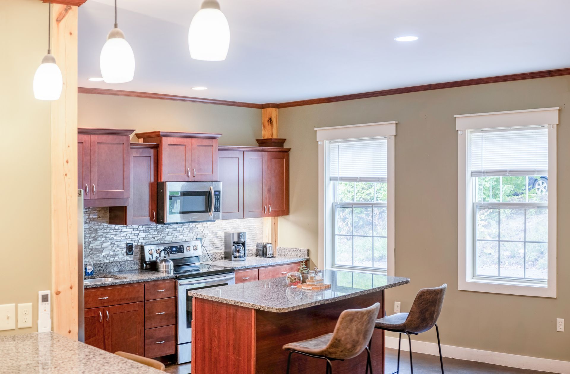 A kitchen with stainless steel appliances , granite counter tops , and wooden cabinets.