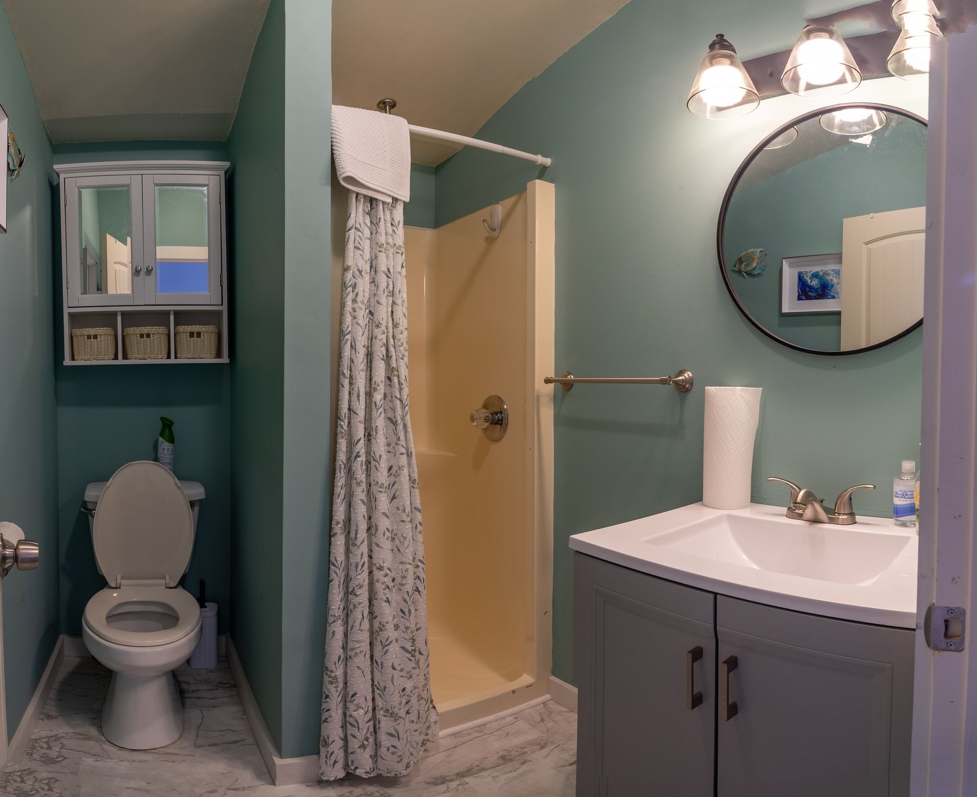 A bathroom with a toilet a sink and a shower