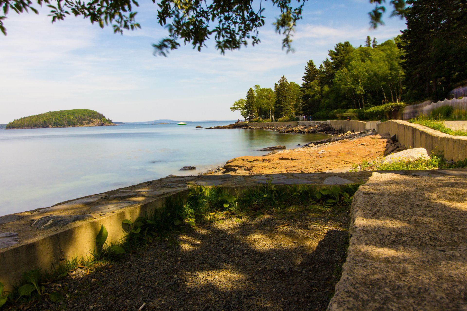 A path leading to a beach next to a body of water.