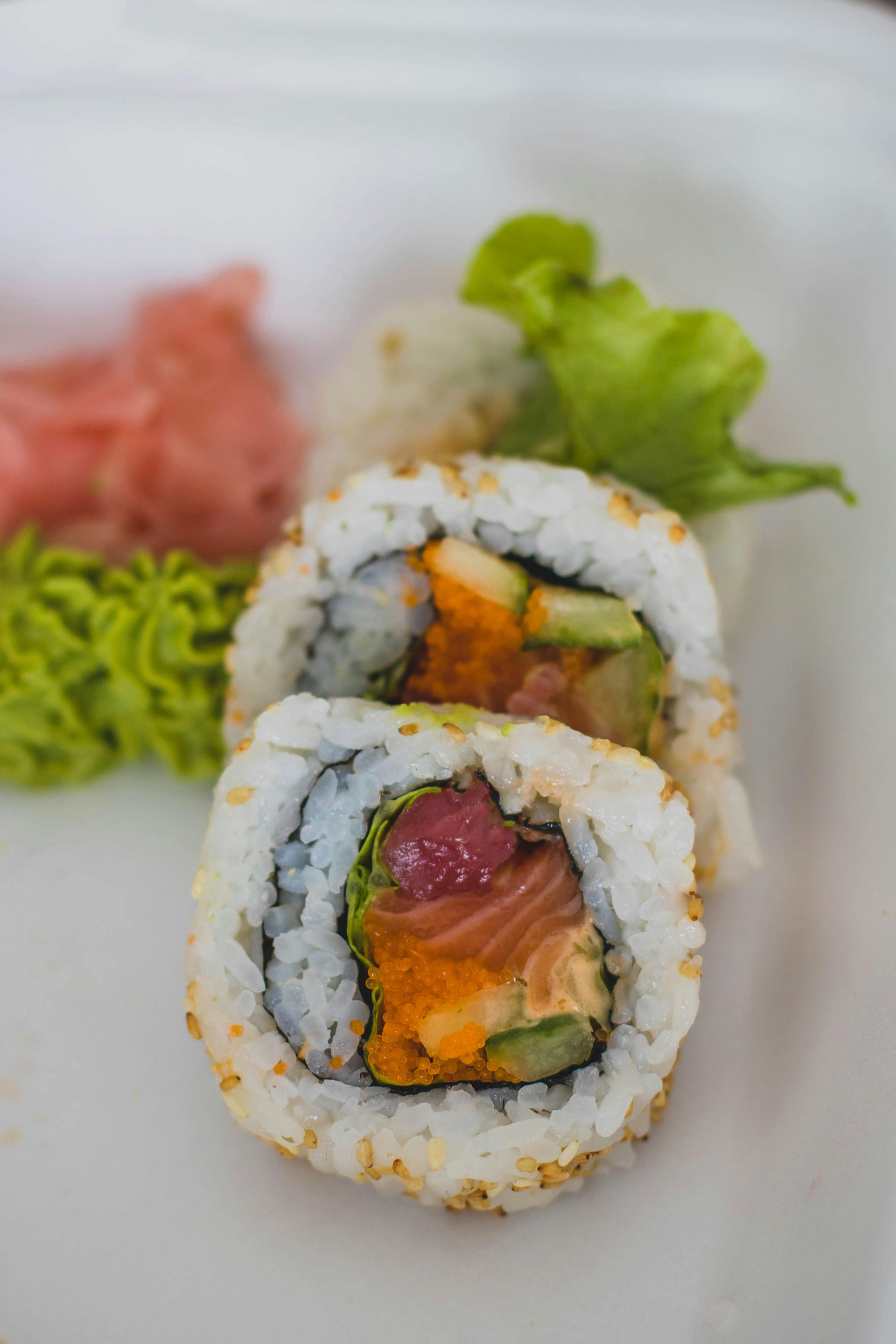 A close up of a sushi roll on a white plate.