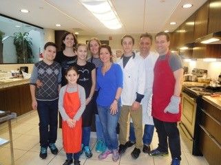 Un groupe de personnes pose pour une photo dans une cuisine.