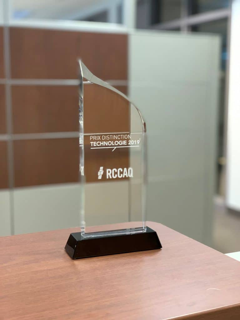 Un trophée en verre est posé sur une table en bois.