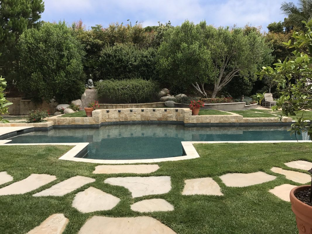 There is a large swimming pool in the middle of the backyard.