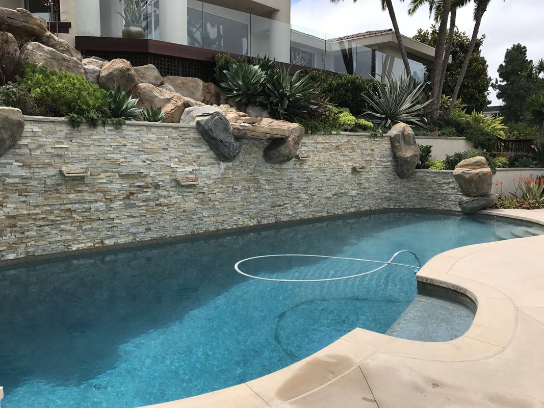 A large swimming pool with a large house in the background.