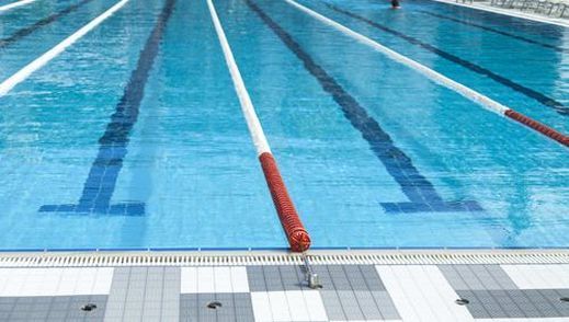 A swimming pool with a lot of lanes and a person in it.