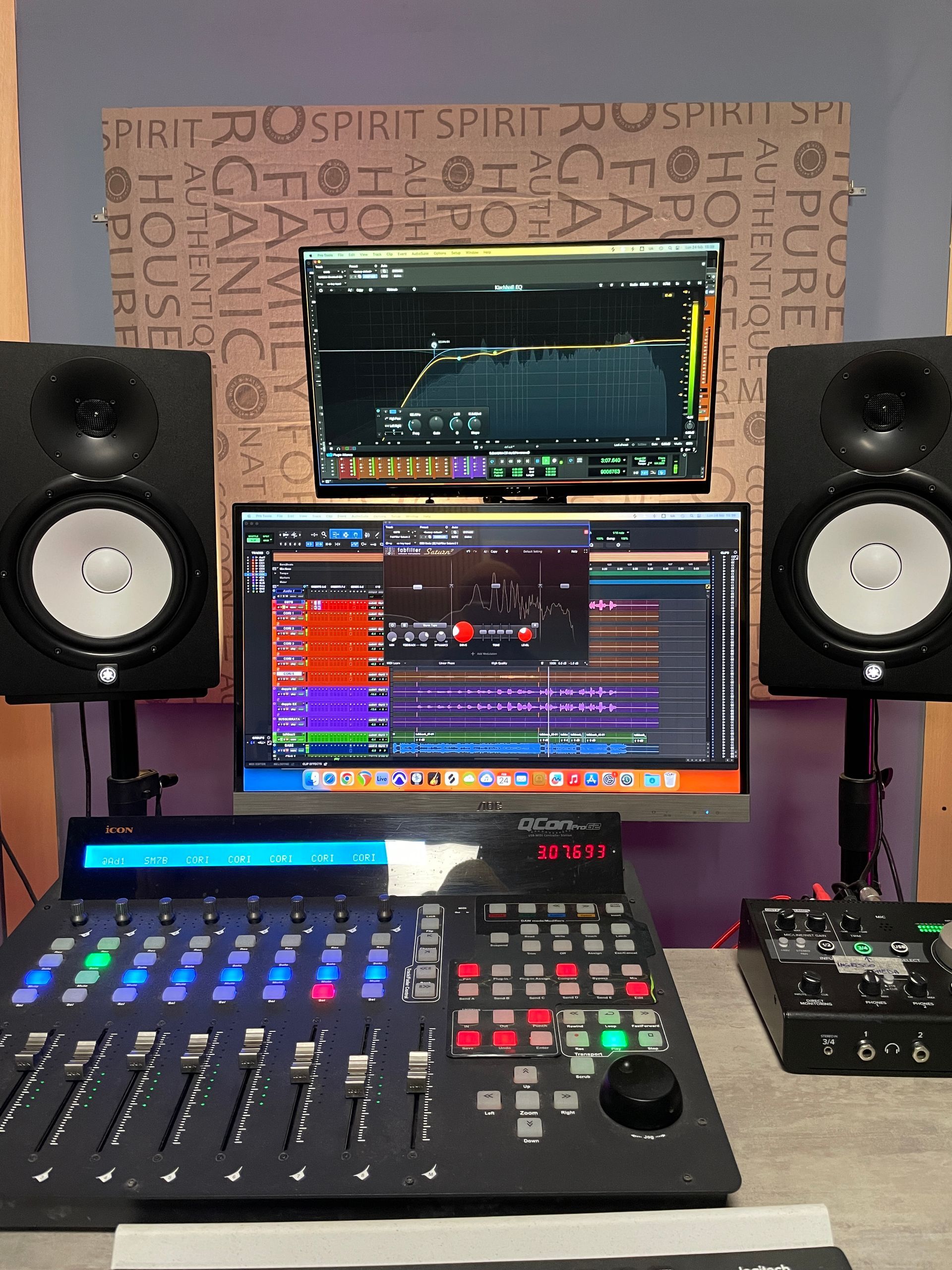 Configurazione dello studio di registrazione con console di missaggio, monitor che visualizzano il software audio e monitor da studio.