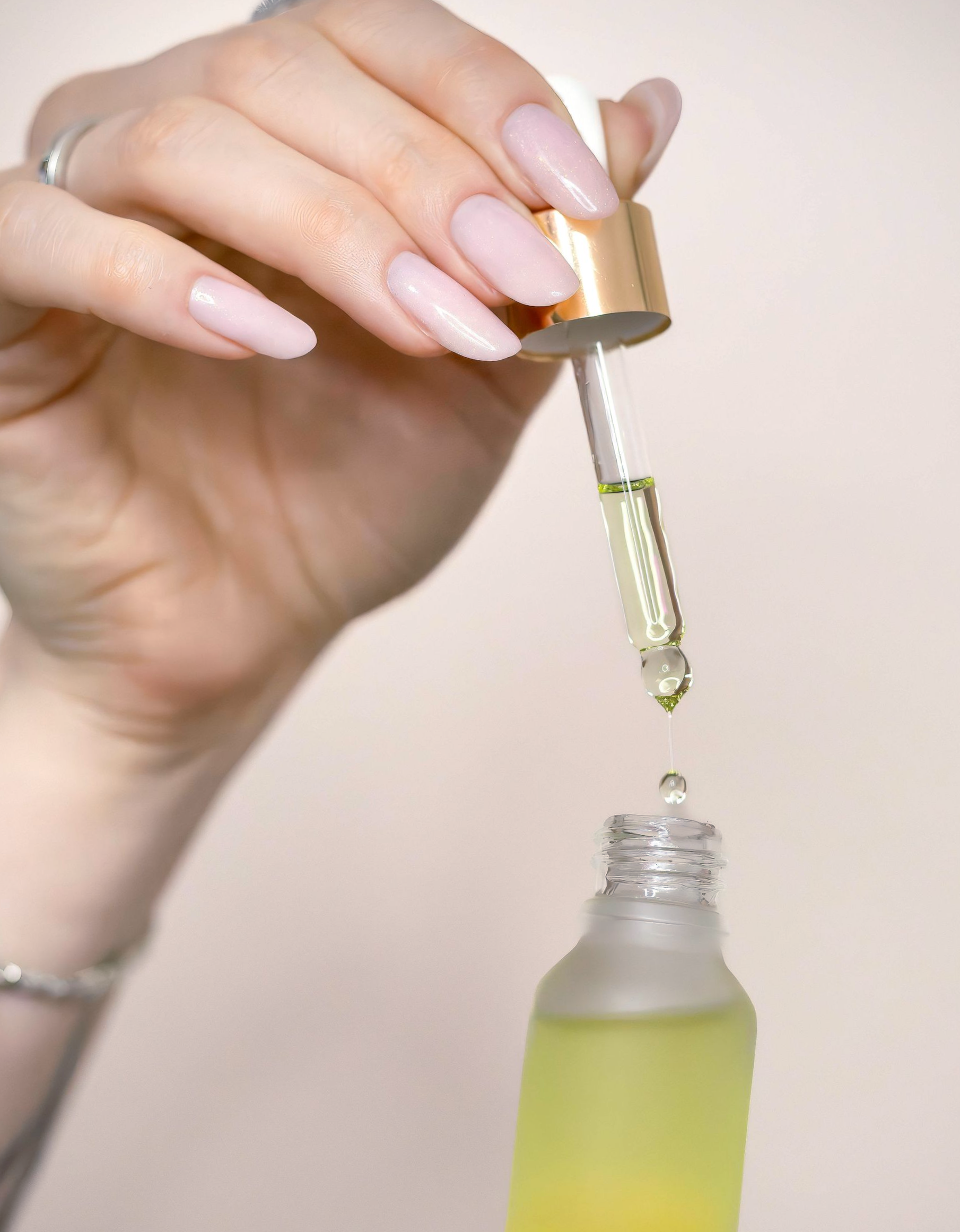 Close-up van verzorgingsproducten zoals handcrème, nagelriemolie en borsteltje– sterke basis voor natuurlijke nagels