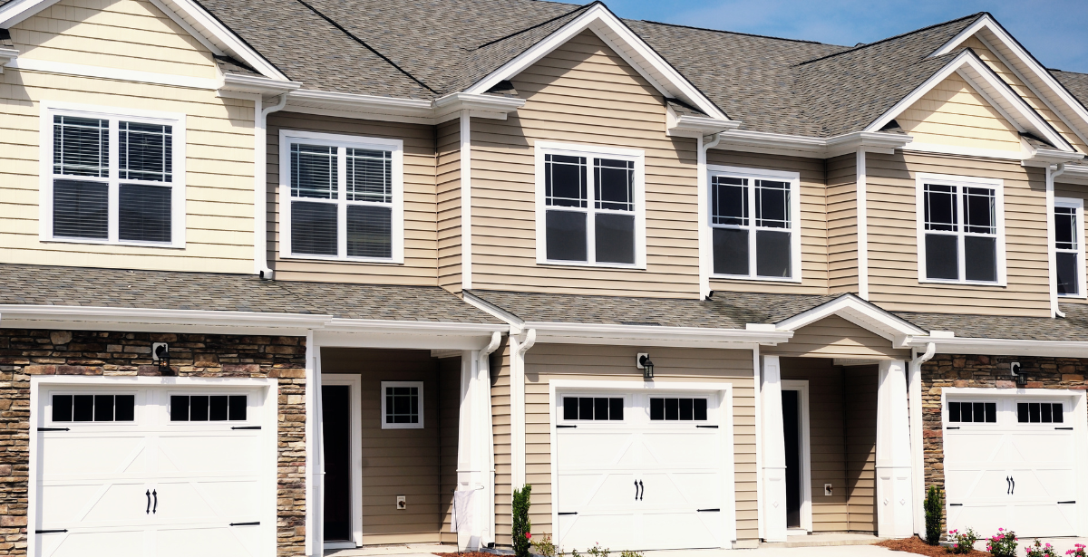 A row of houses with white garage doors and windows. A row of houses with white garage doors and windows.