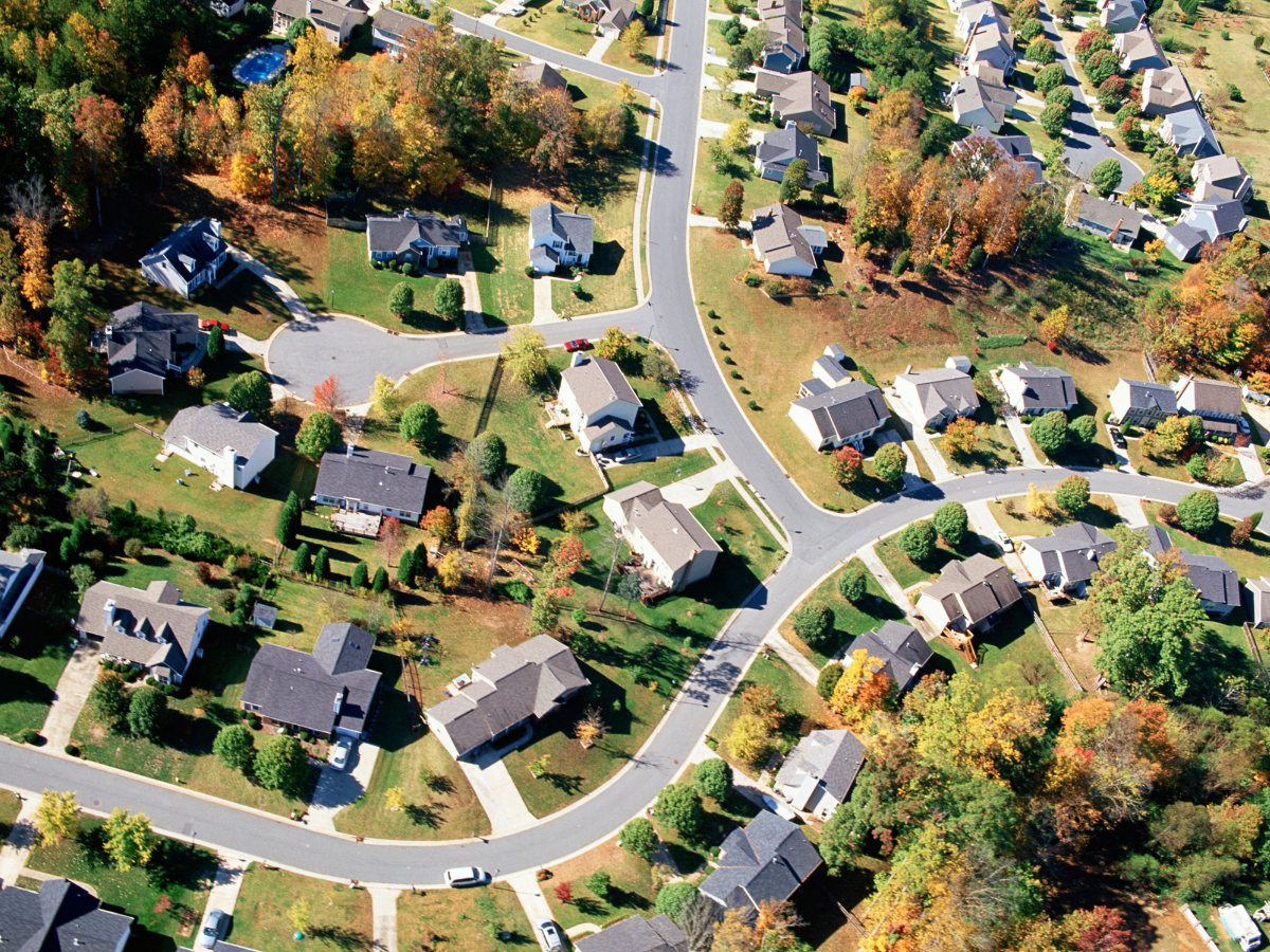 An aerial view of a residential neighborhood with lots of houses and trees An aerial view of a residential neighborhood with lots of houses and trees
