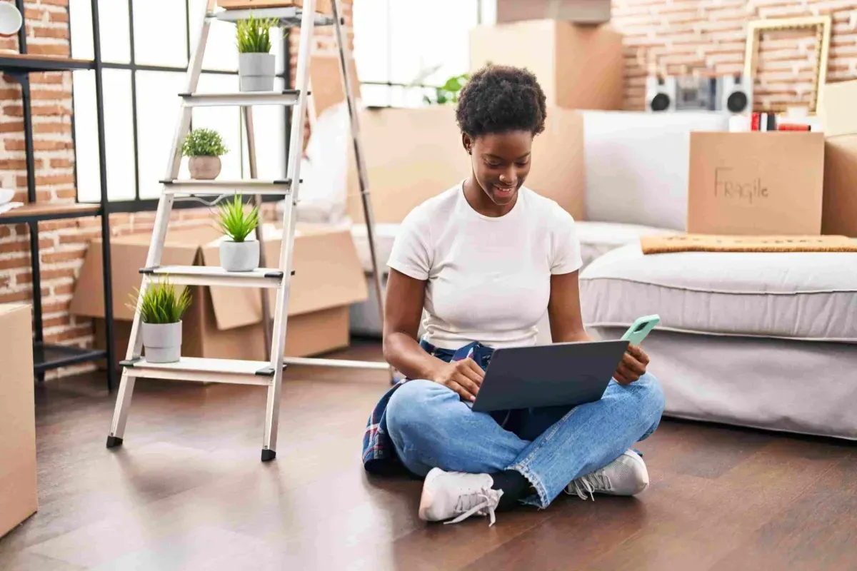A woman is sitting on the floor using a laptop computer. A woman is sitting on the floor using a laptop computer.