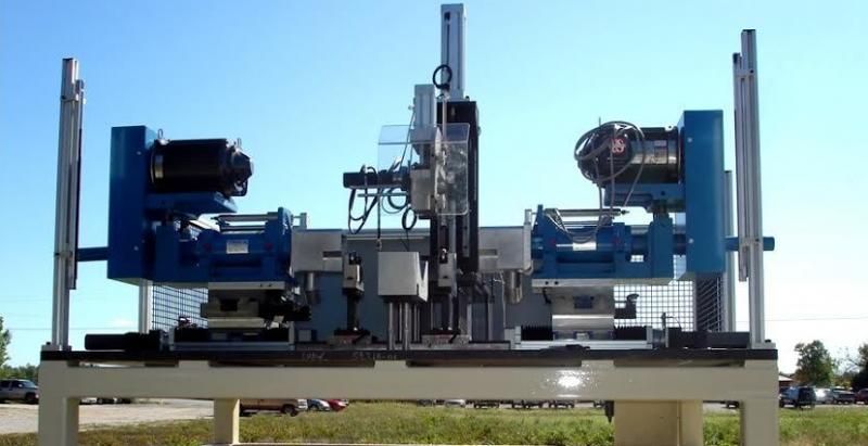 Blue industrial machine on a metal platform outdoors against a clear sky