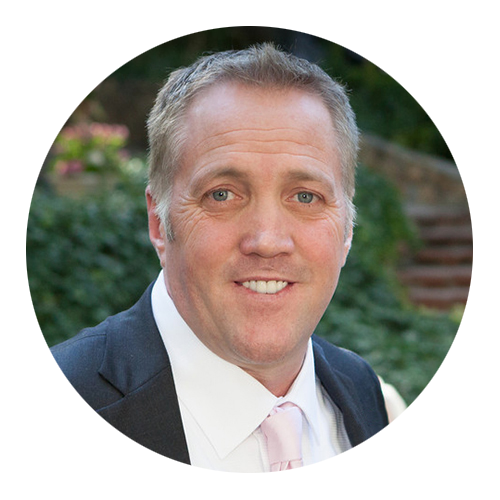 A man in a suit and tie is smiling in a circle