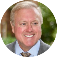 A man in a suit and tie is smiling in a circle.