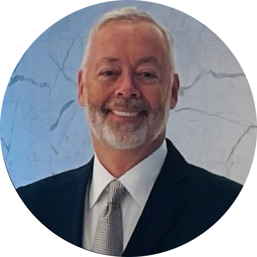 A man in a suit and tie smiles for the camera
