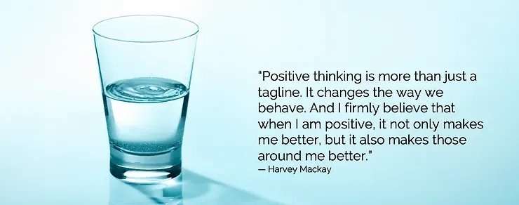 A glass of water with a quote about positive thinking