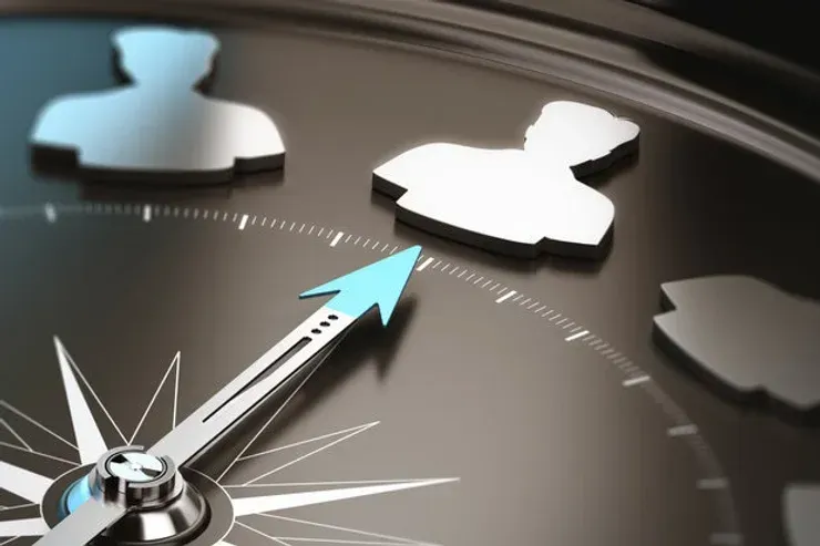 A close up of a compass with a blue arrow pointing to the right