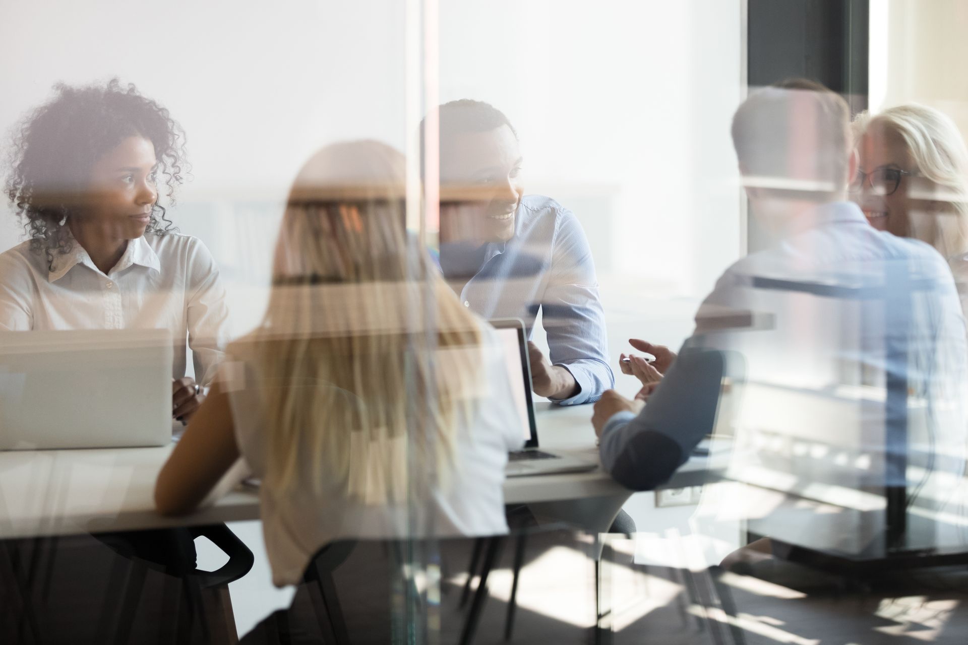 A group of people are sitting around a table having a meeting.