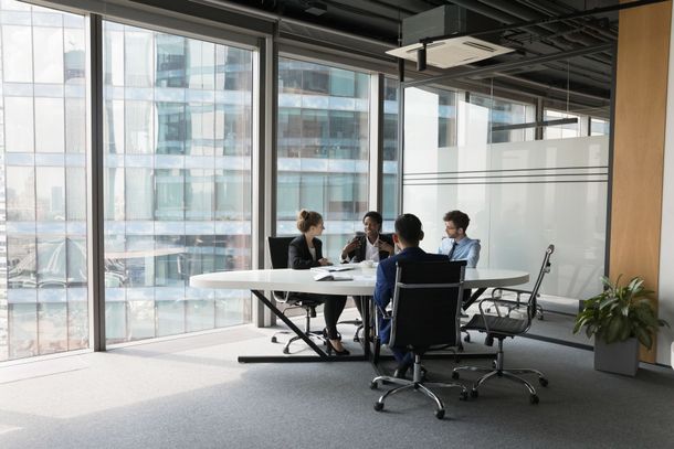 A group of people are sitting around a table in a conference room.