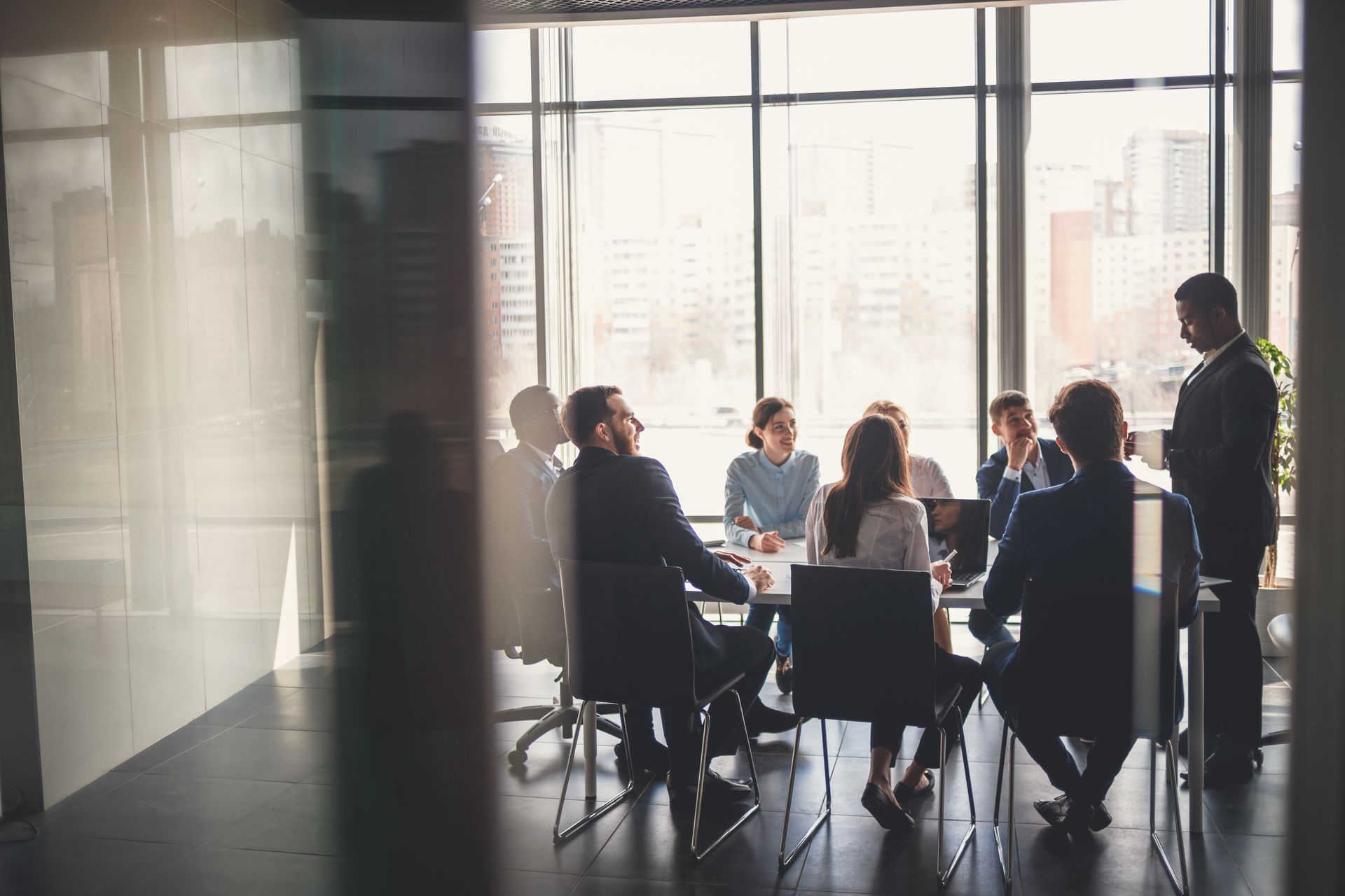 A group of people are sitting around a table in a conference room.