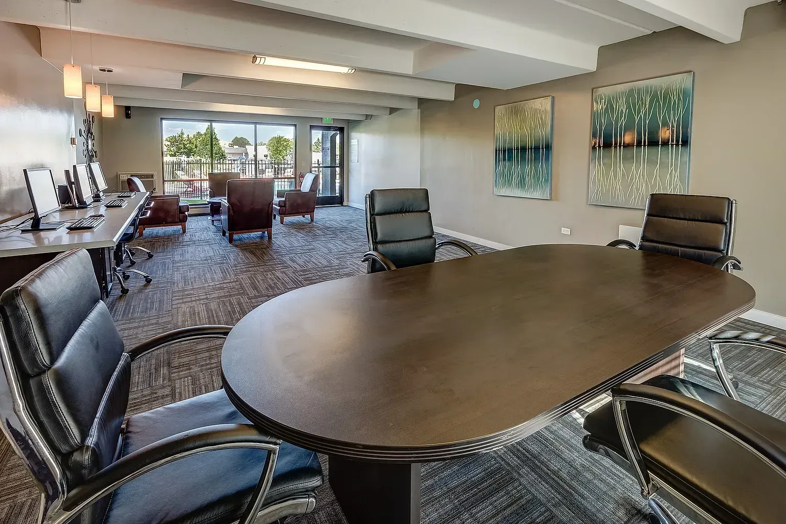 Business center with computers and a conference table.