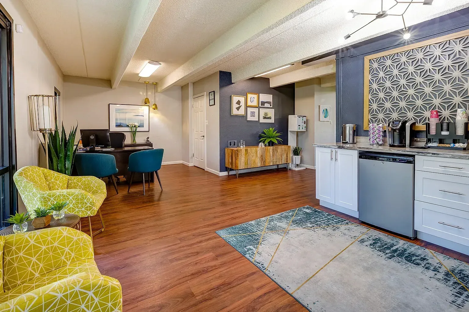 Office reception area with a desk, seating, and a coffee station.