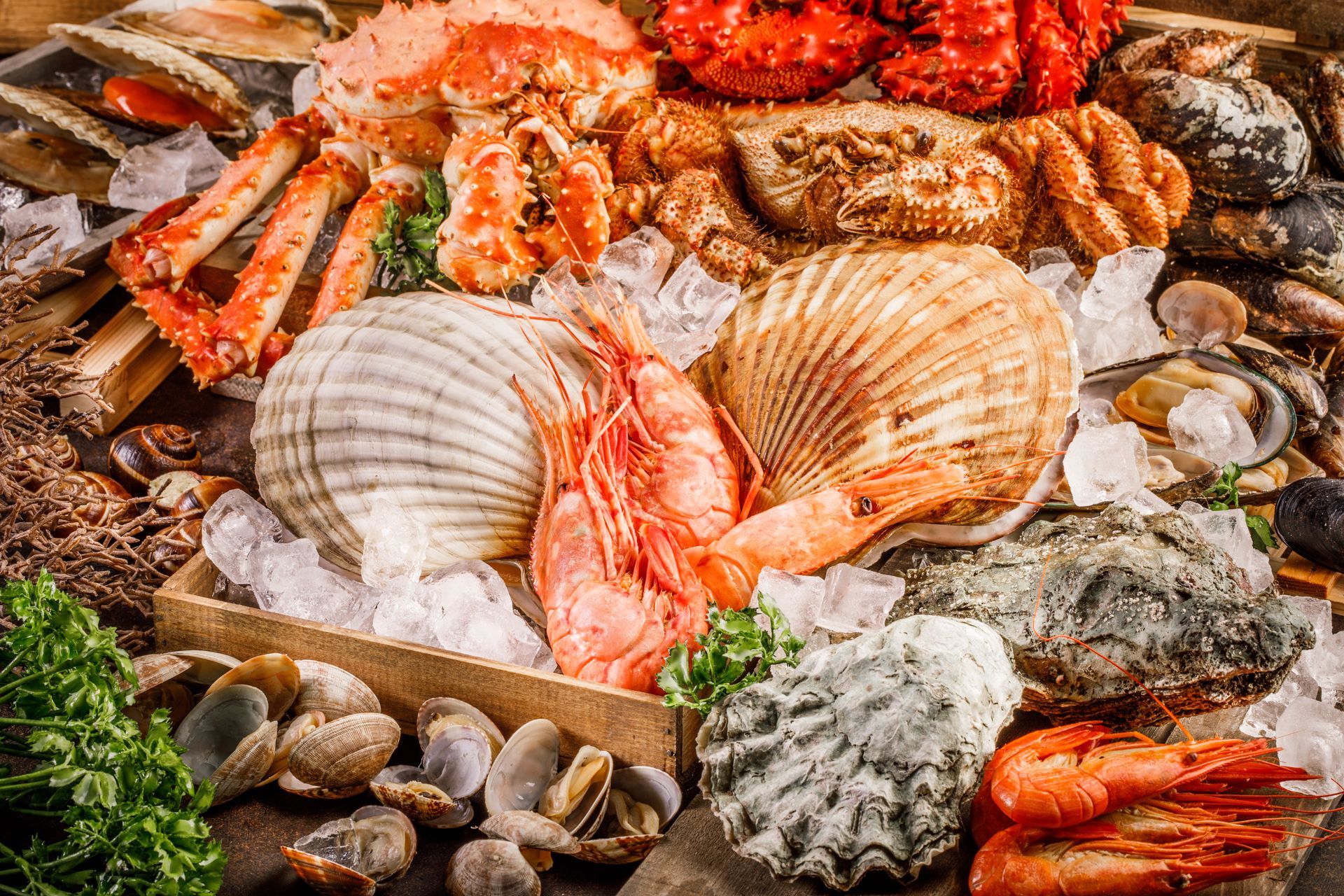 Assorted seafood display with large scallops, crab, shrimp, and shellfish on ice