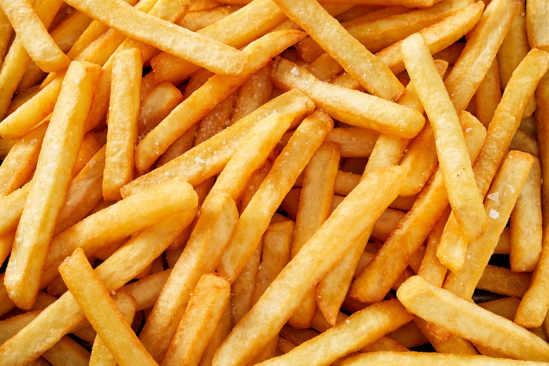 Close-up of golden French fries piled together