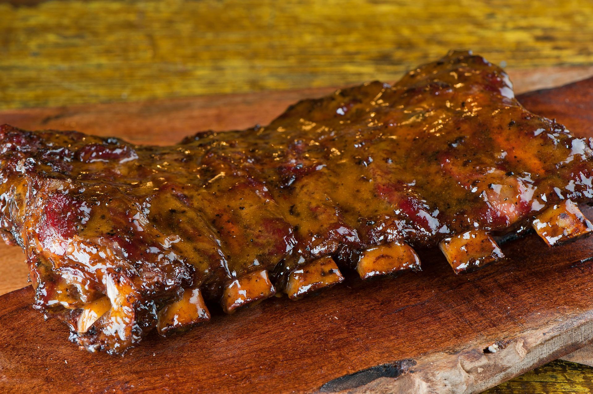 Barbecue ribs glazed with sauce on a wooden cutting board Barbecue ribs glazed with sauce on a wooden cutting board