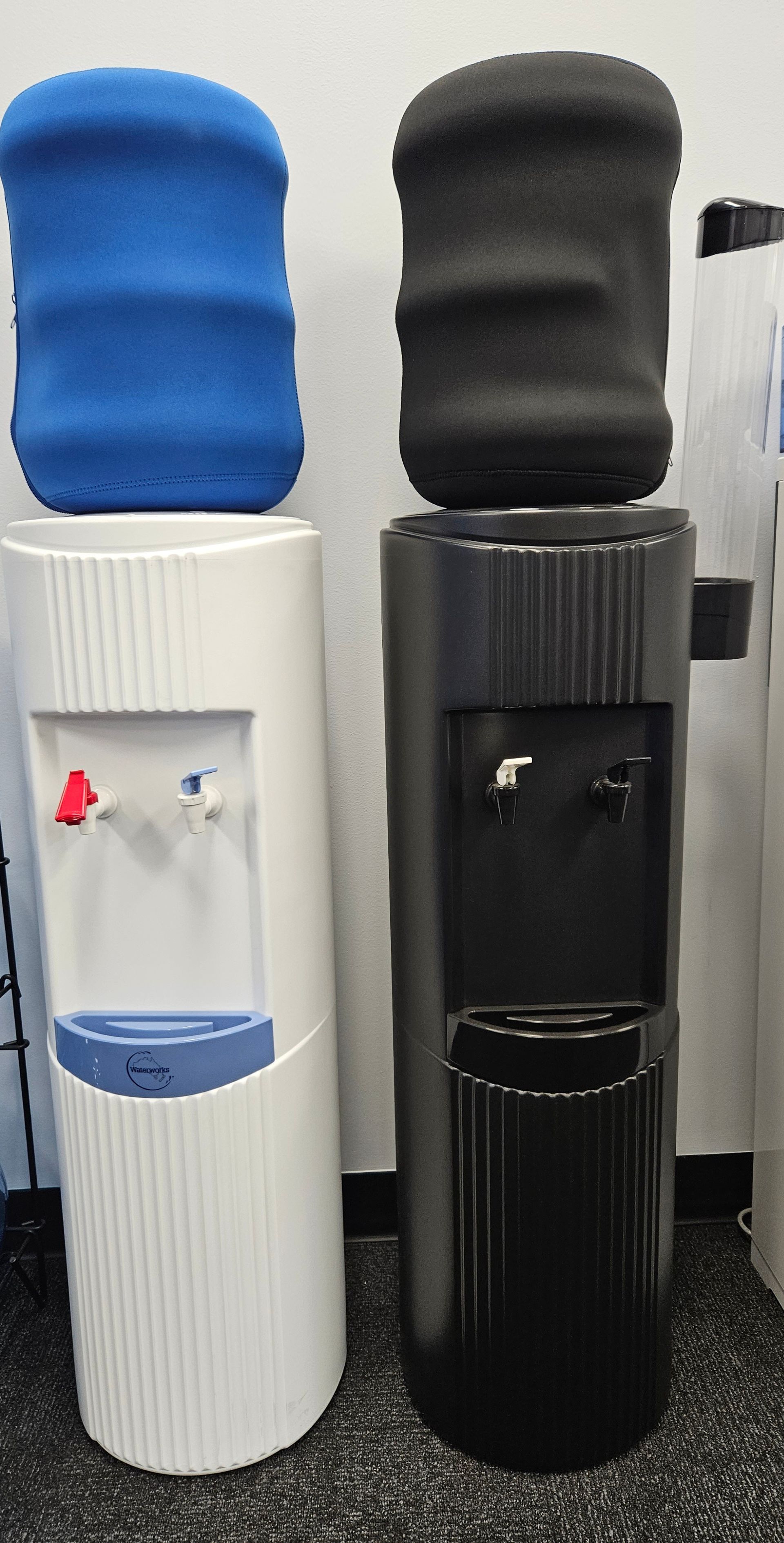 Two Water Dispensers, One Blue And One Black, Are Sitting Next To Each Other — Billabong Springs in Jimboomba, QLD