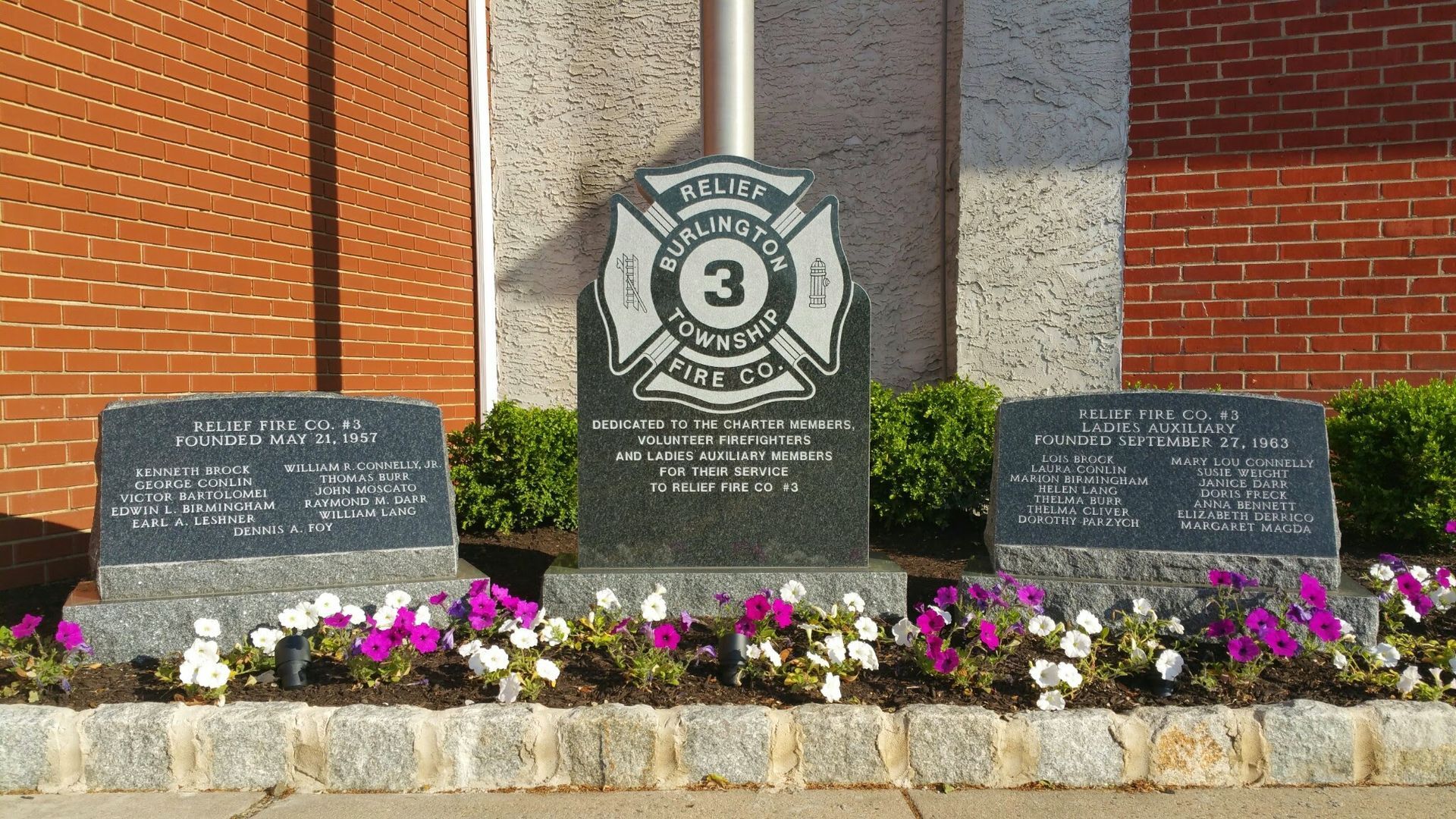 A granite memorial with a central emblem for Edginton Township Fire Co. 3, flanked by two engraved tribute markers.