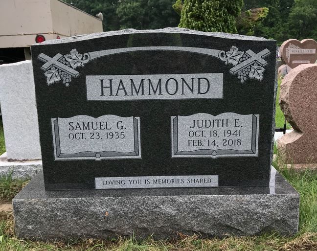 A black granite upright headstone engraved with