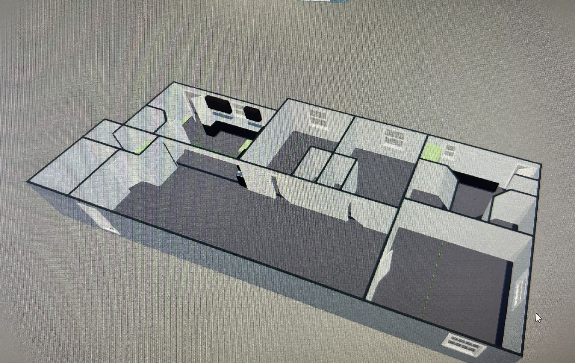 3D architectural floor plan of a building, with gray walls and floors, showing rooms and doorways.