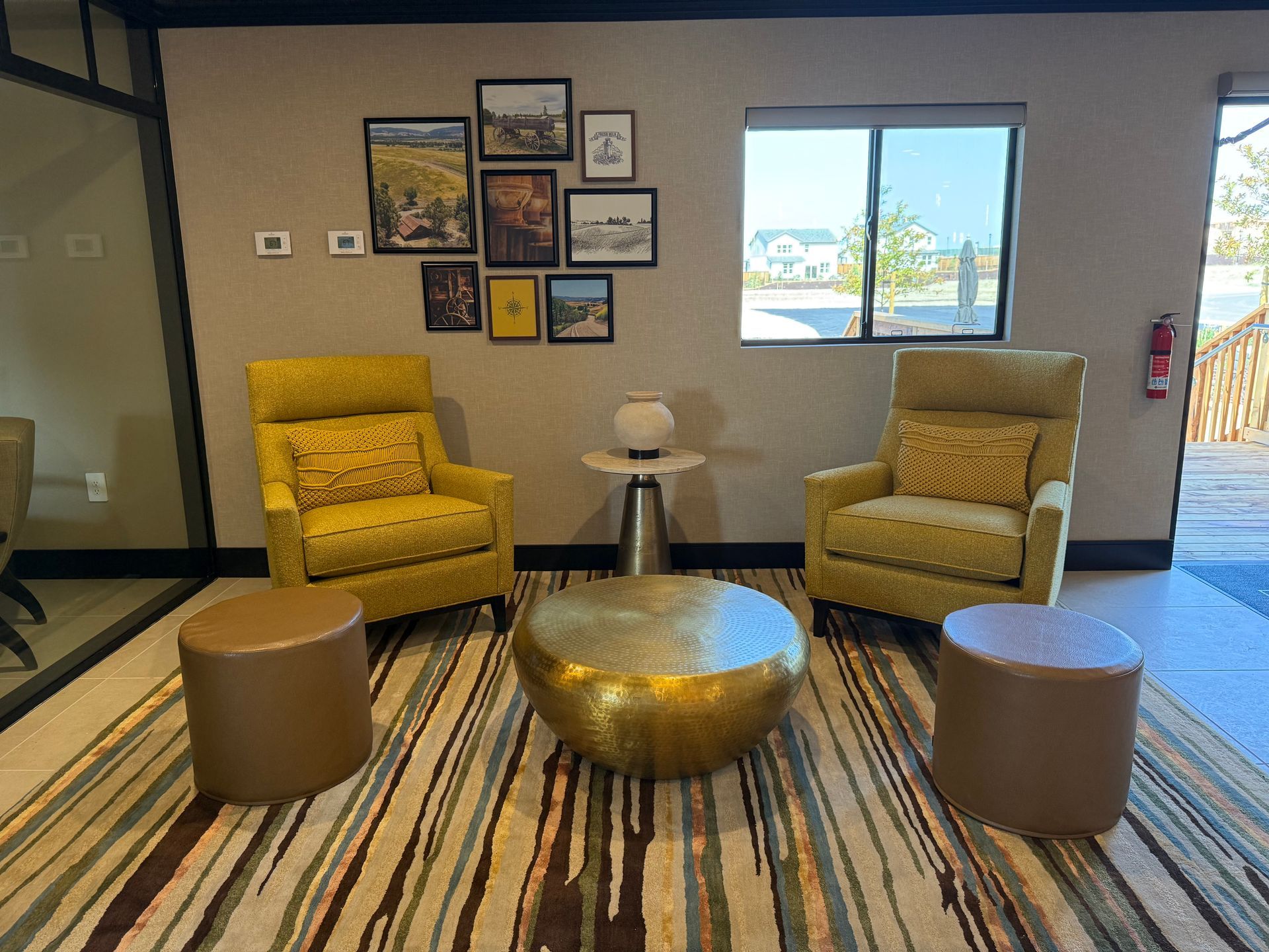 A living room with yellow chairs and a gold coffee table.