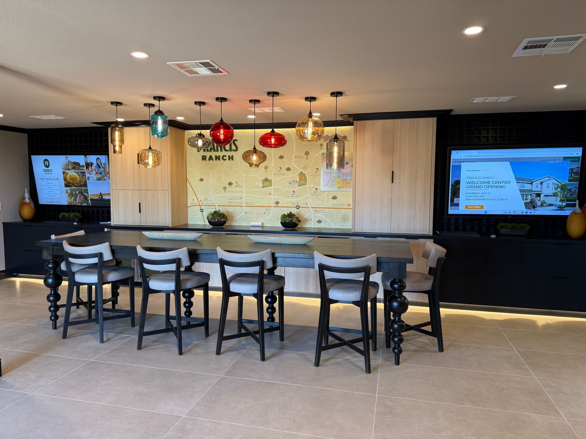 A large room with a table and chairs and two televisions.