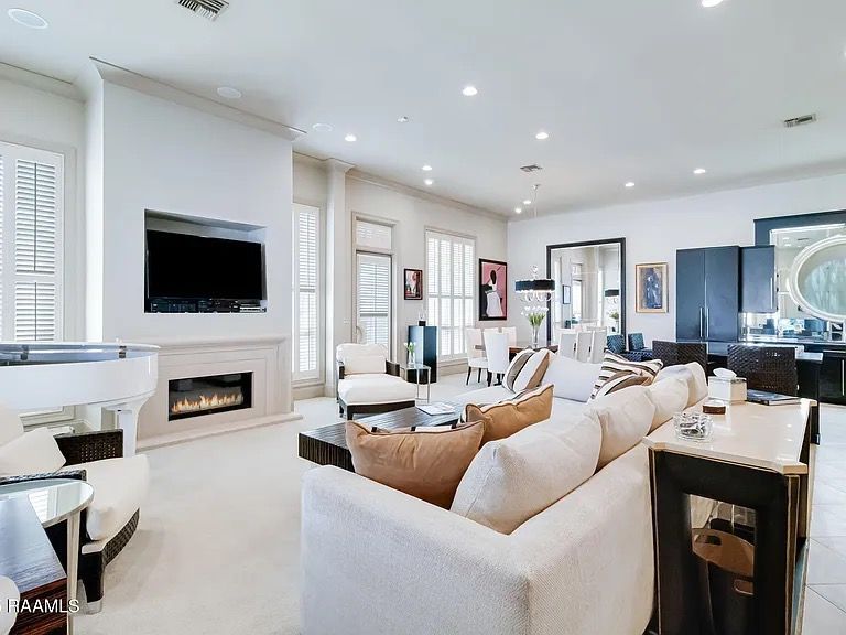 A living room with a couch , fireplace , television and piano.