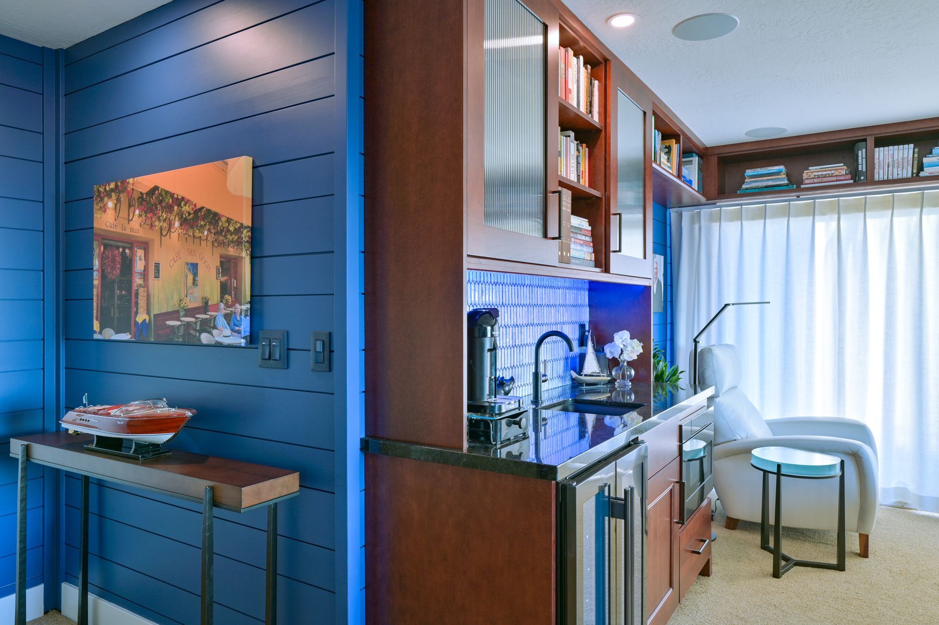 a living room with blue walls and a bar