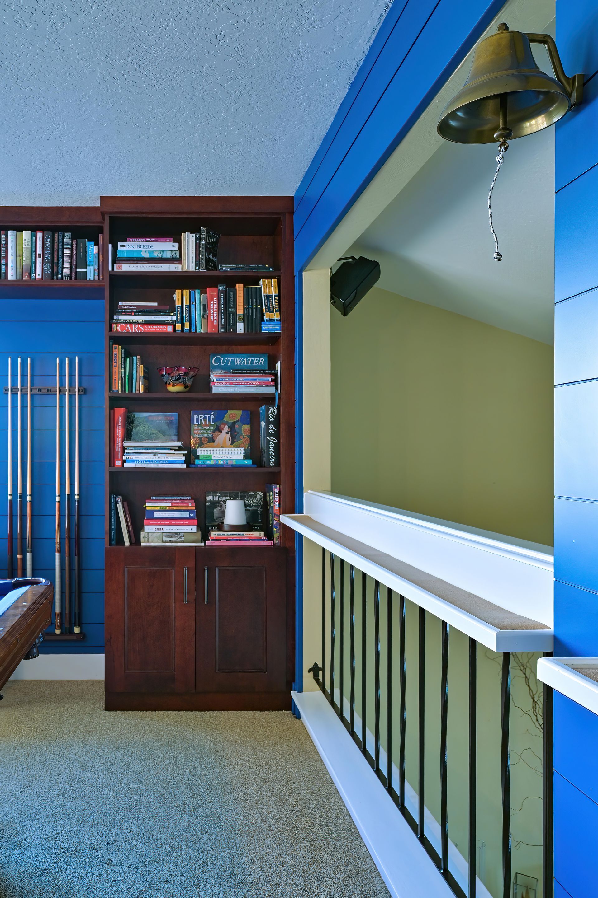 a room with a pool table and a bookshelf with books on it
