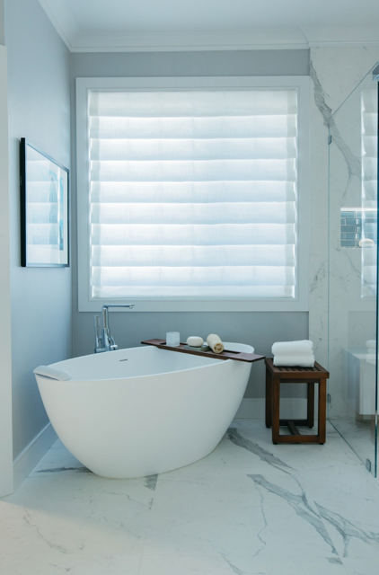 A bathtub in a bathroom next to a window
