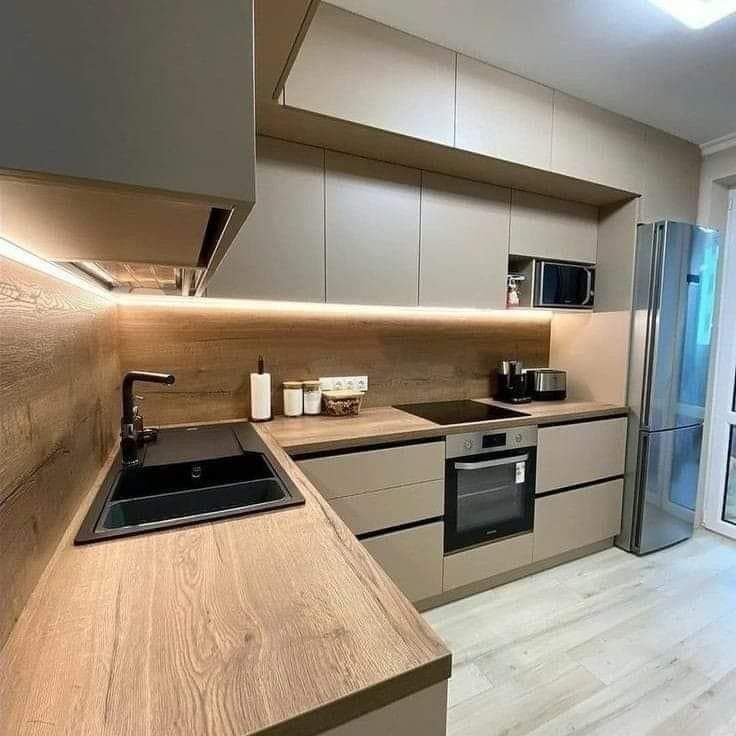 Une cuisine avec un évier, une cuisinière, un réfrigérateur et un micro-ondes.