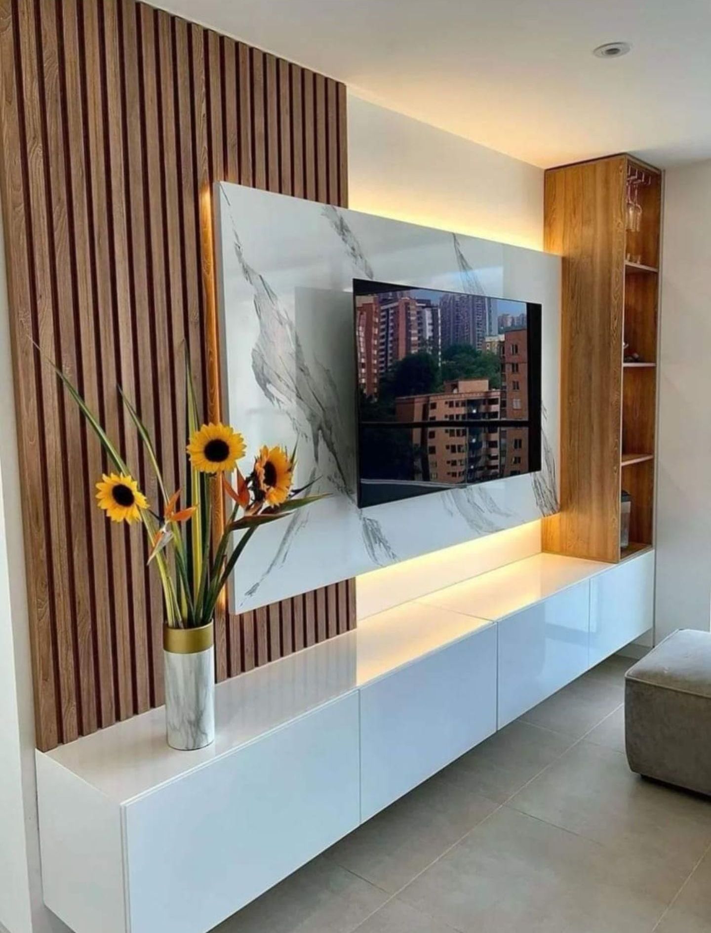 Un salon avec une télévision à écran plat fixée au mur.