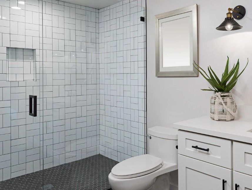 Derbyshire Plumbing & Heating Specialists wet room with white tiling installed in Ilkeston
